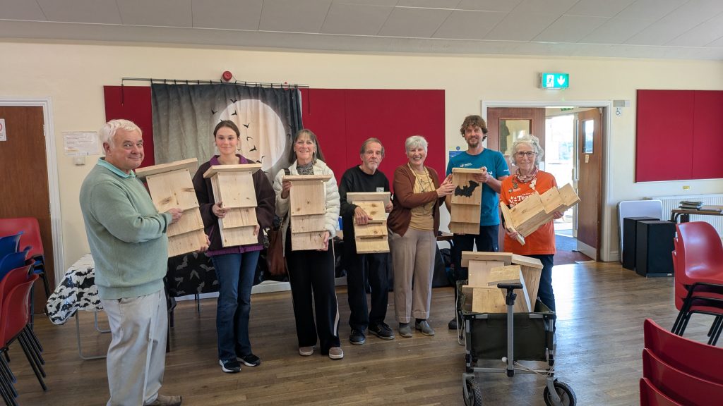 A group of volunteers displaying bat boxes